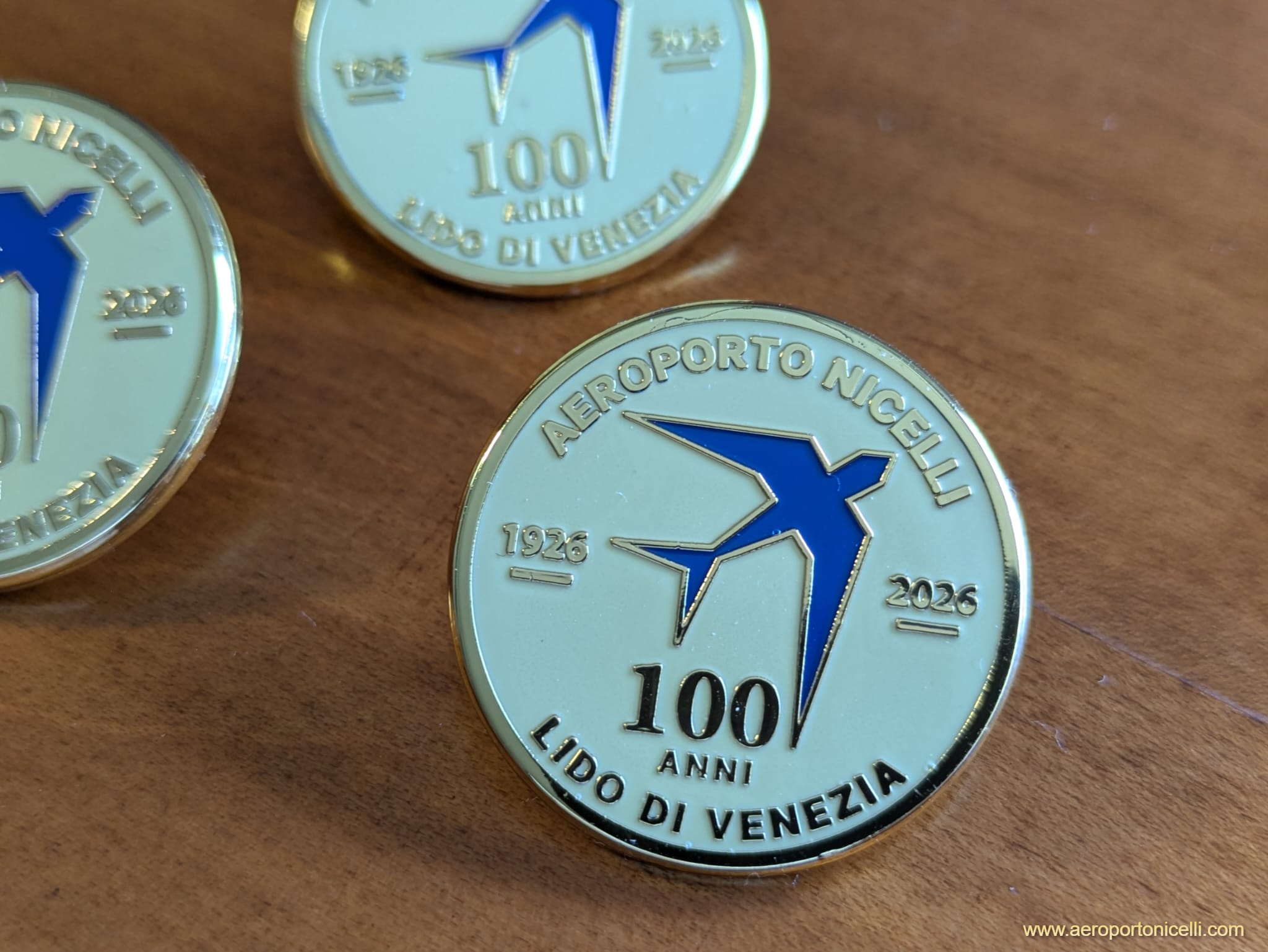 Medaglia celebrativa per il centenario dell'Aeroporto Nicelli di Venezia, con il logo e la scritta '100 ANNI LIDO DI VENEZIA 1926-2026'.